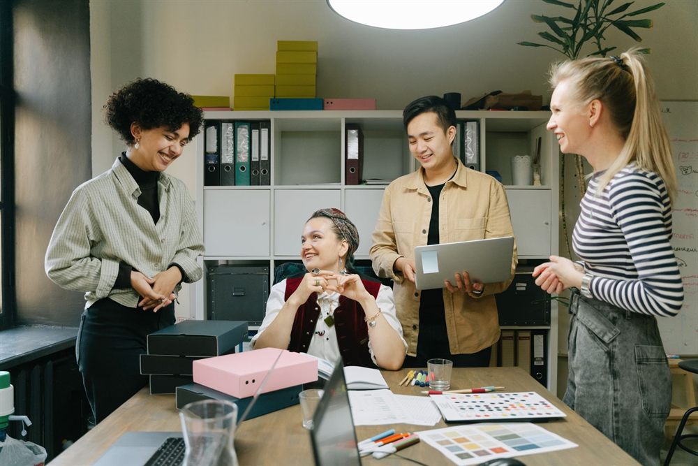 Small team sharing ideas around a desk in a studio office