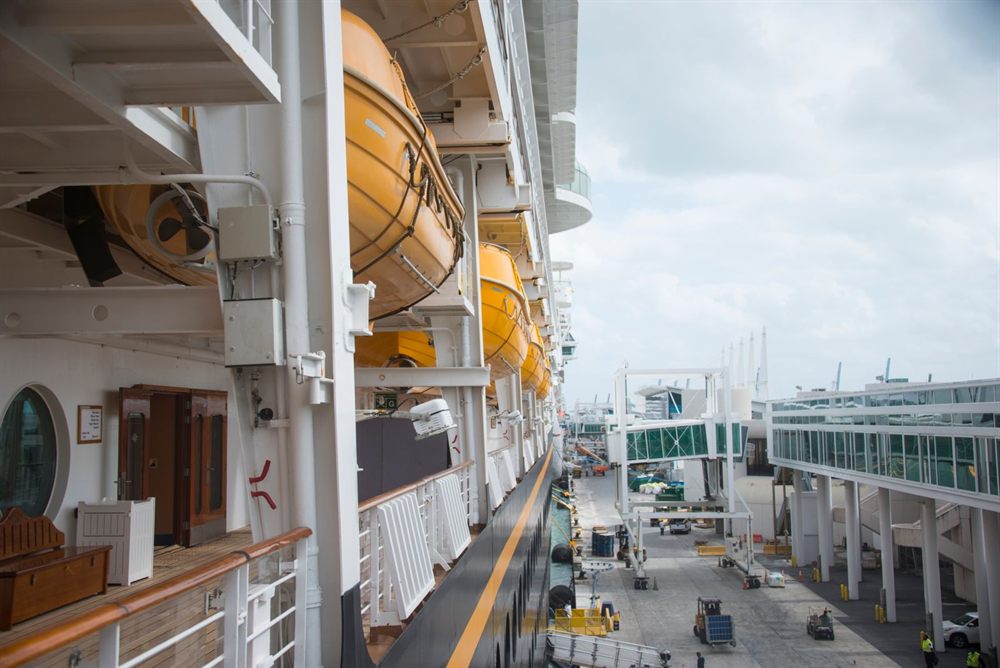 View along a cruise ship’s side deck toward the port terminal