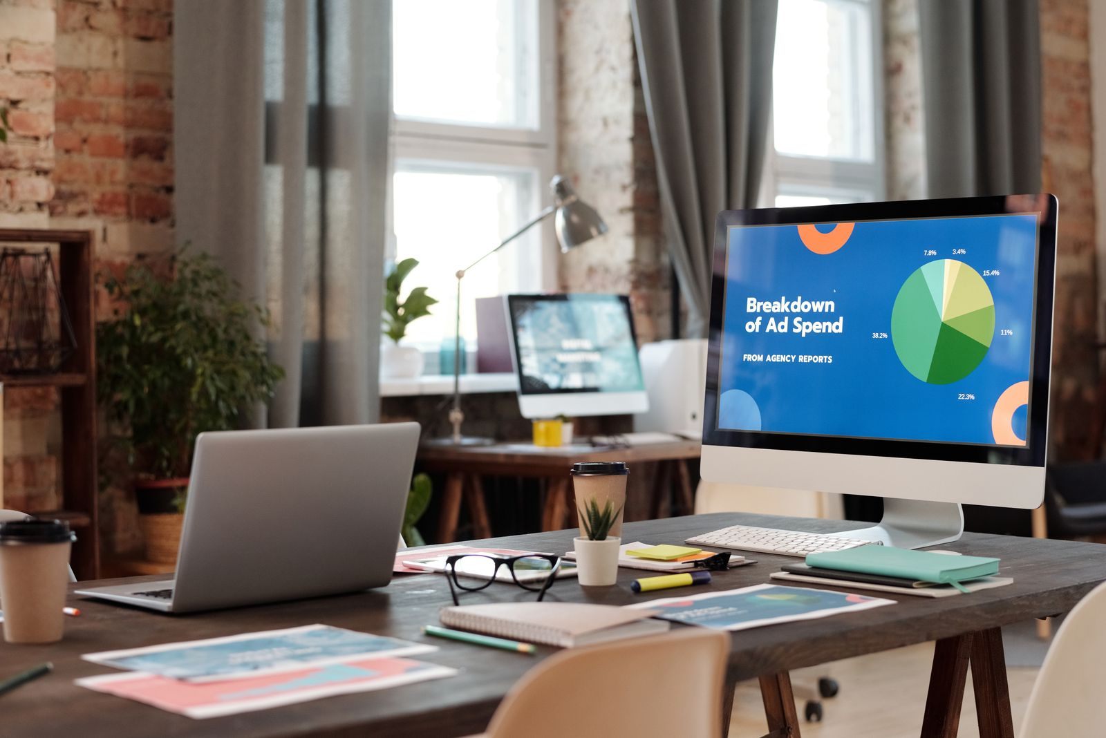 Office desk with a monitor showing an advertising spend chart