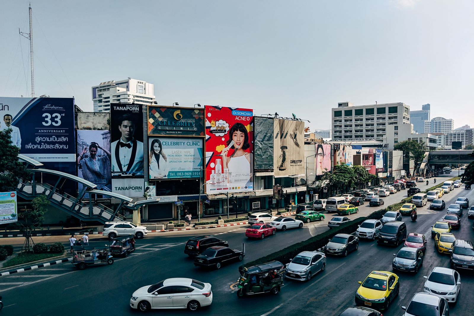 Large advertising billboards above a busy city road